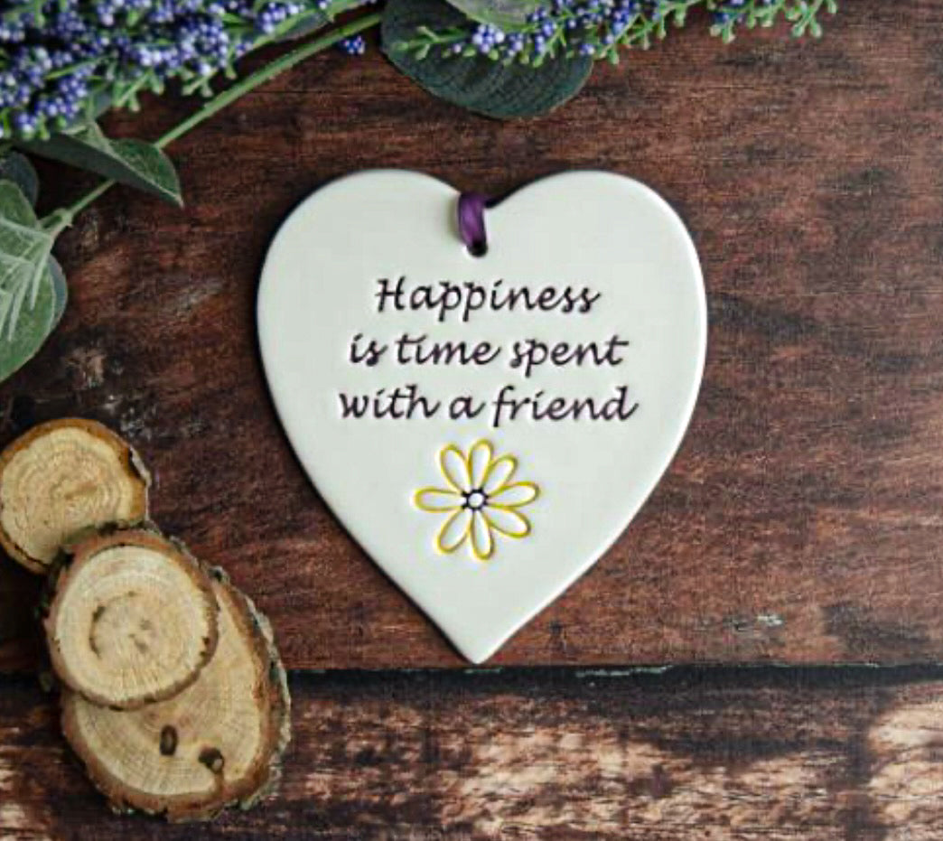 Happiness Ceramic Gift Tag with the text which read, "happiness is time spent with a friend" surrounded by foliage