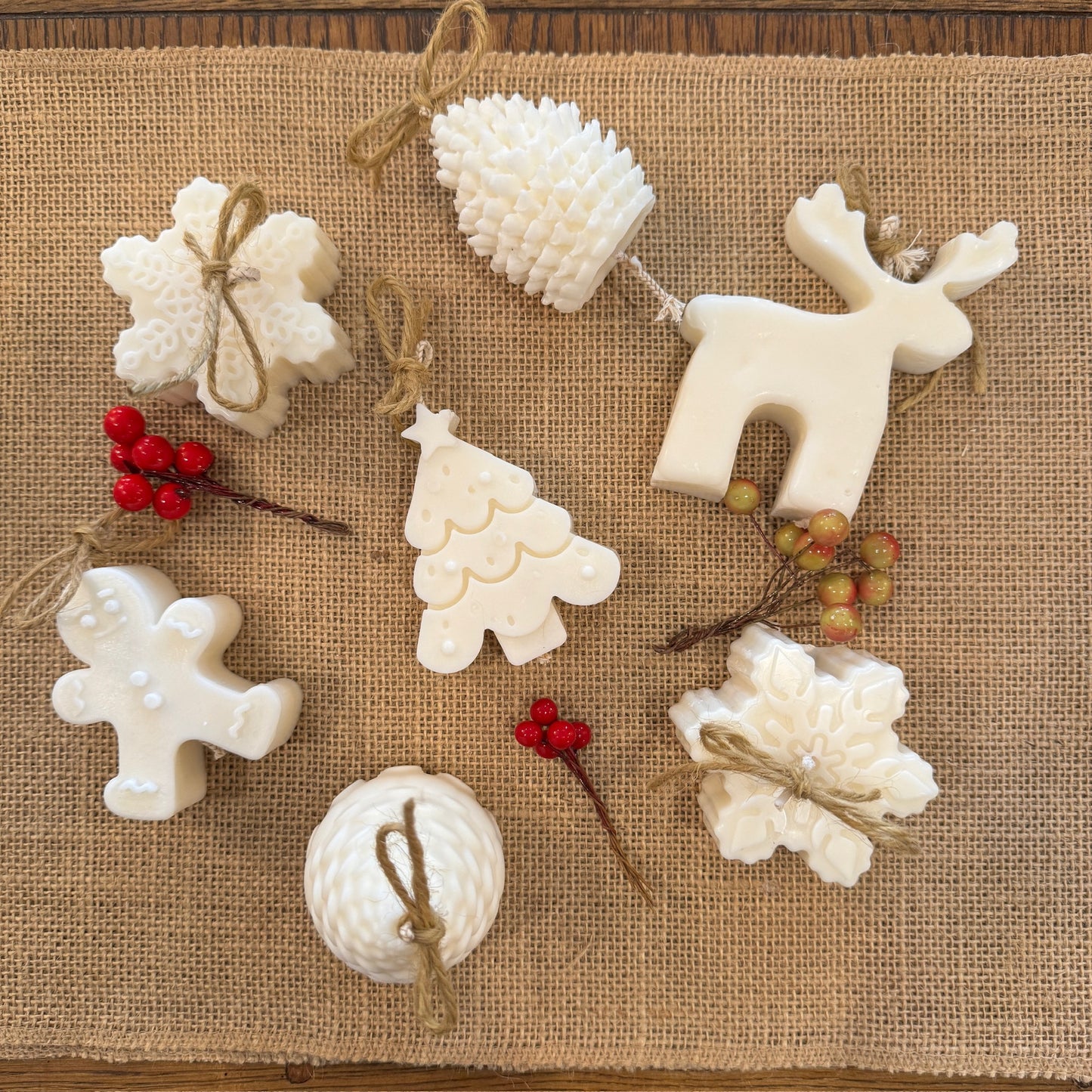 mini Christmas candle selection, includes pine cone, reindeer, Christmas tree, ginger bread man and snowflake on hessian sheet