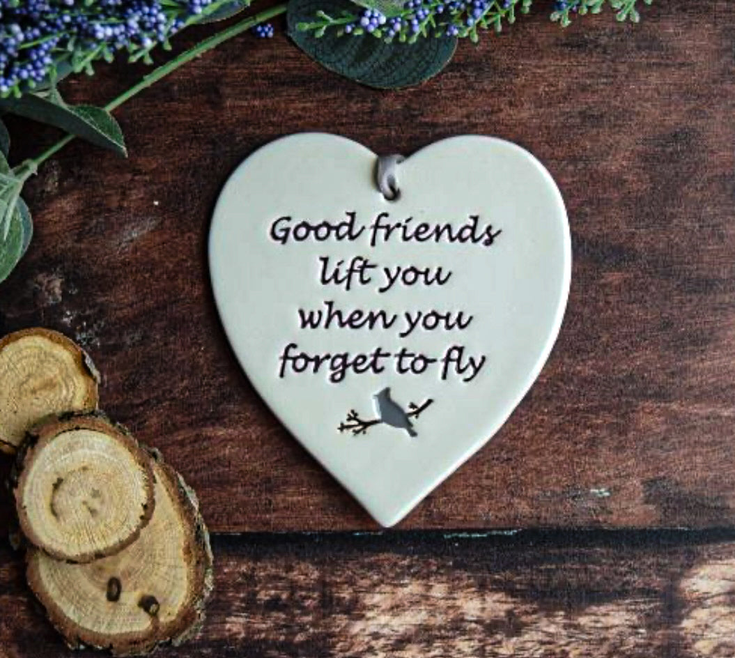 Fly Ceramic gift Tag with the text saying "good friends lift you when you forget to fly" surrounded by foliage