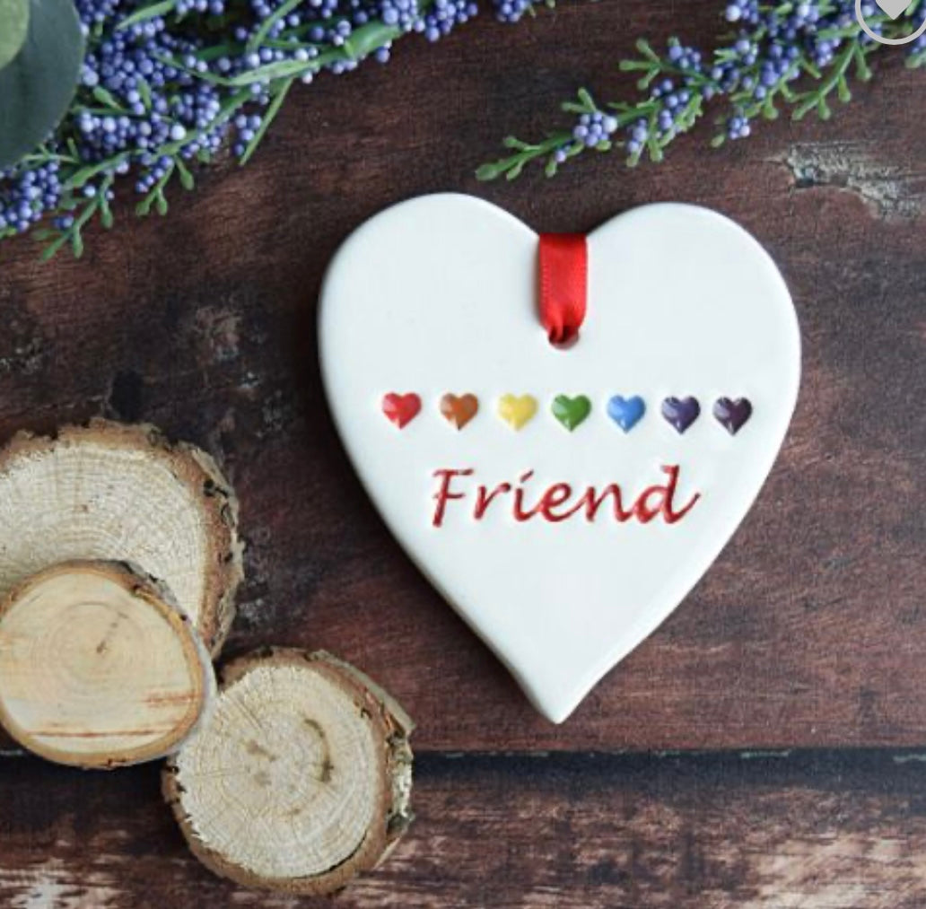 Friend Ceramic Gift Tag with rainbow coloured love hearts and text saying "friend" surrounded by foliage