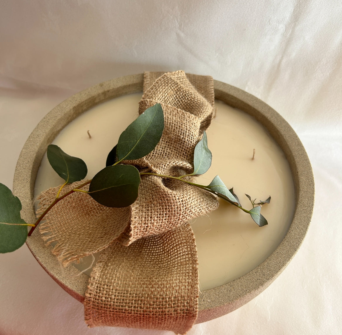 large bowl candle with hessian bow and foliage