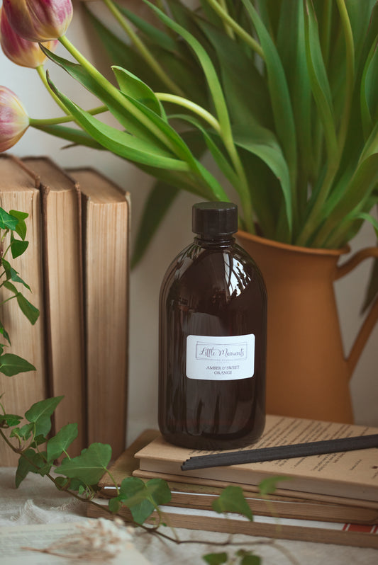 Brown bottle with books and plant in the background