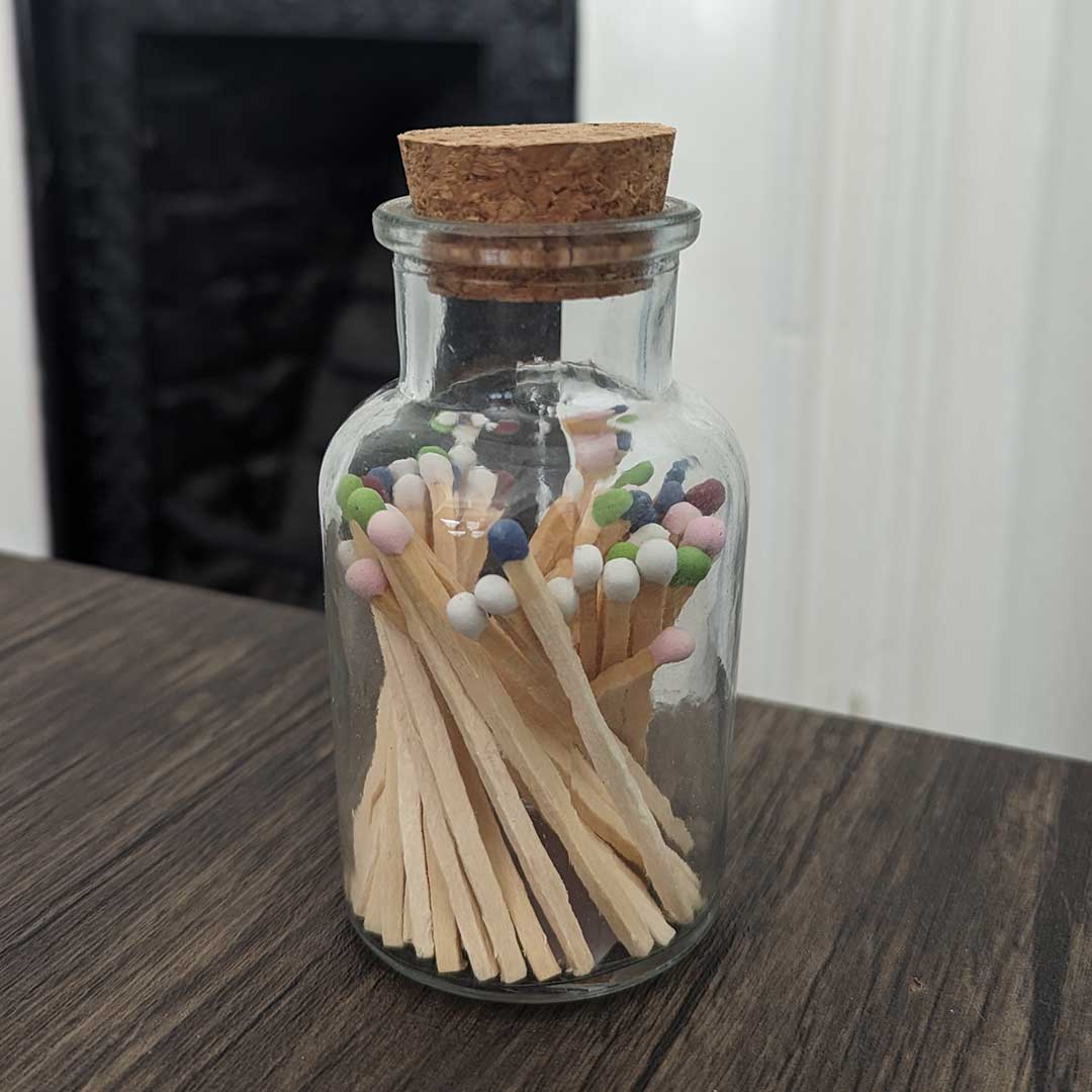 stylish glass jar with cork lid containing match sticks of various colours