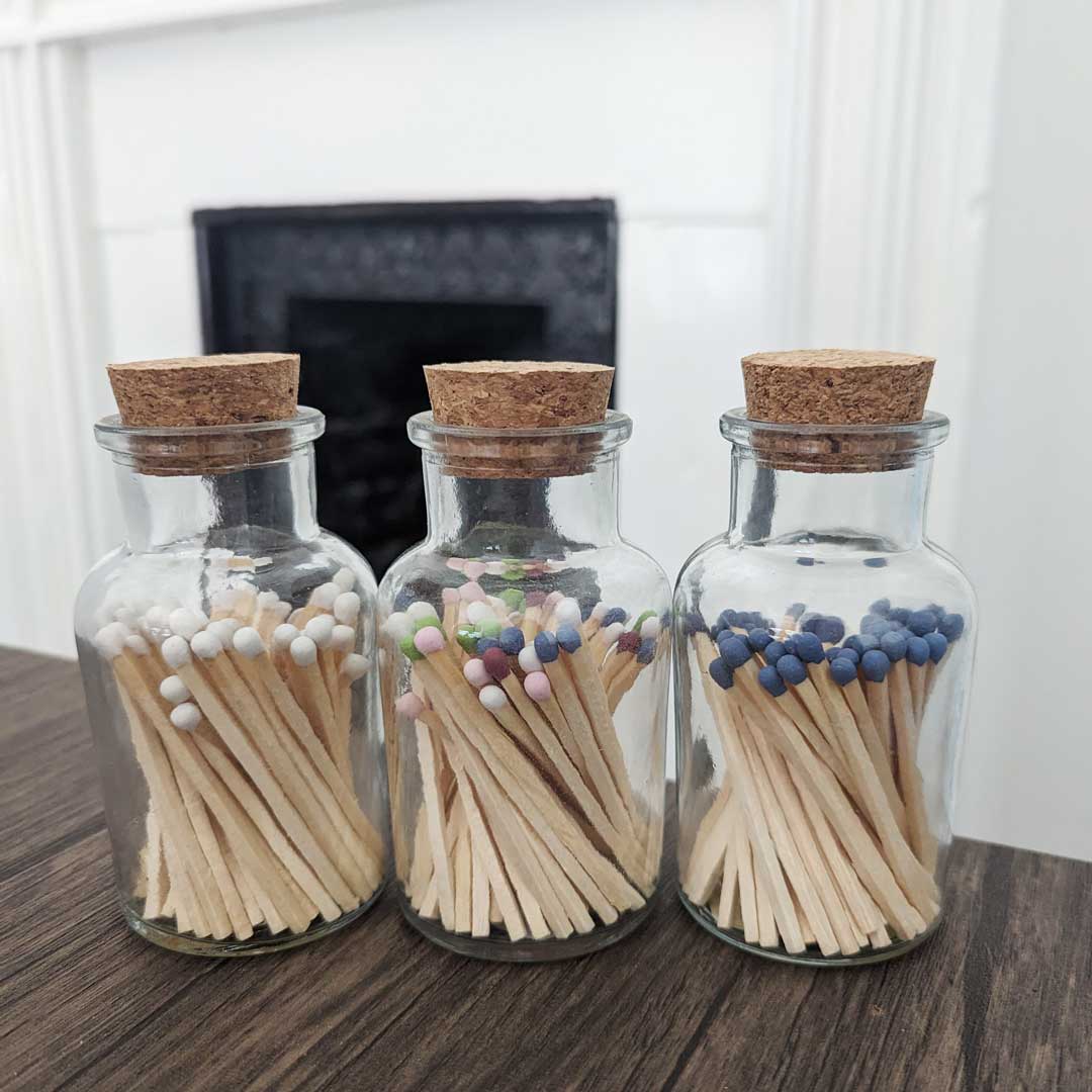 glass jar with cork lid containing long matches of varying colours