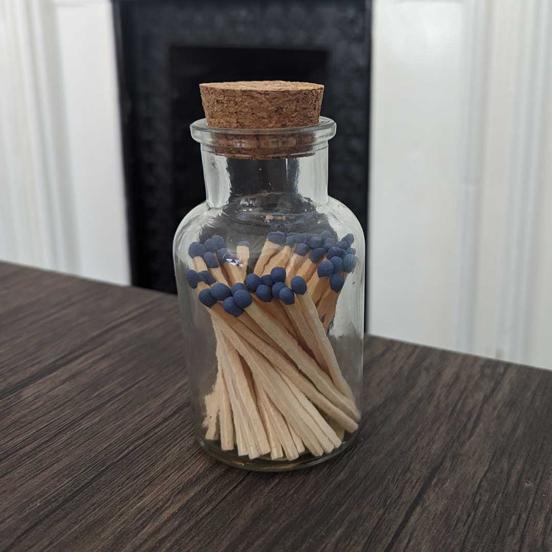 stylish glass jar with cork lid containing blue match sticks