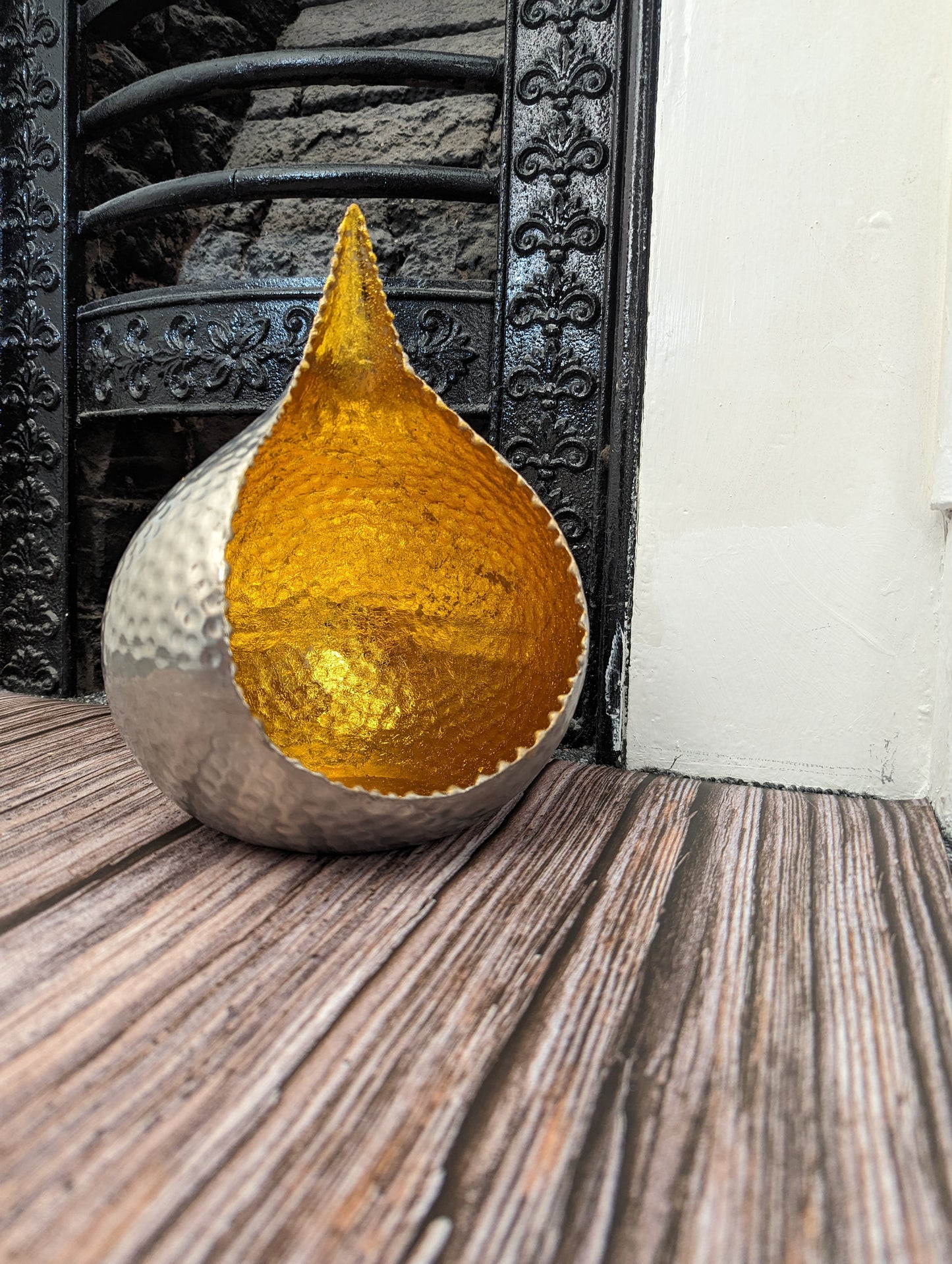 Hammered metal glow bowl reflecting tealight candlelight in a cozy setting