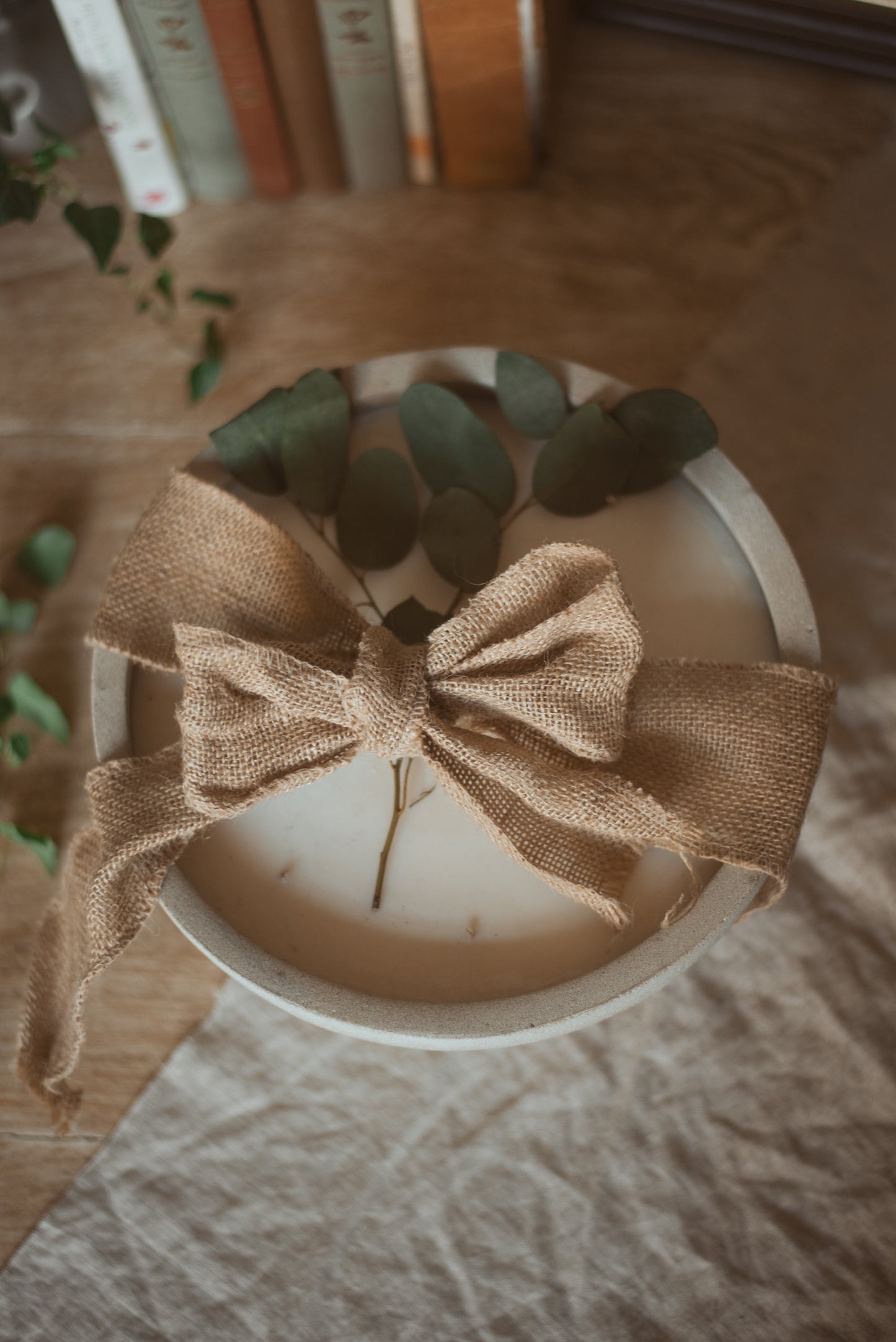 large bowl candle with 12 wicks, wrapped up in hessian ribbon  and foliage 