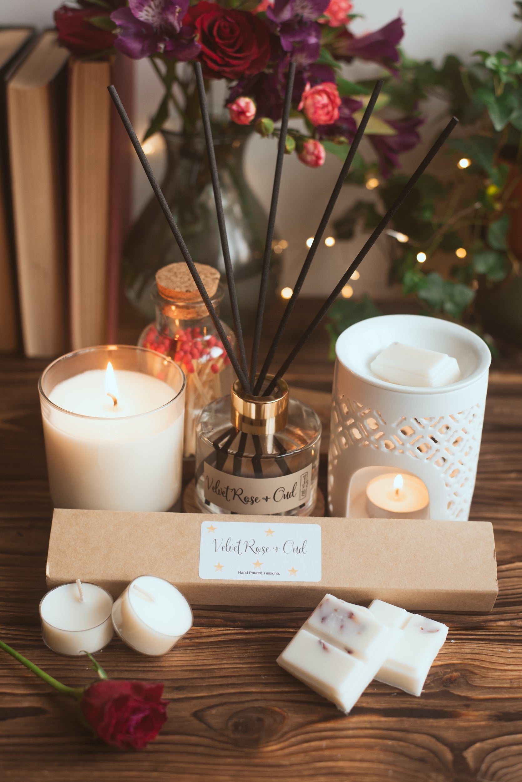 Candle, diffuser, and other decorative items on a wooden surface with a blurred background.