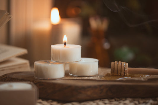 three tea lights stacked in a pyramid, top candle is lit
