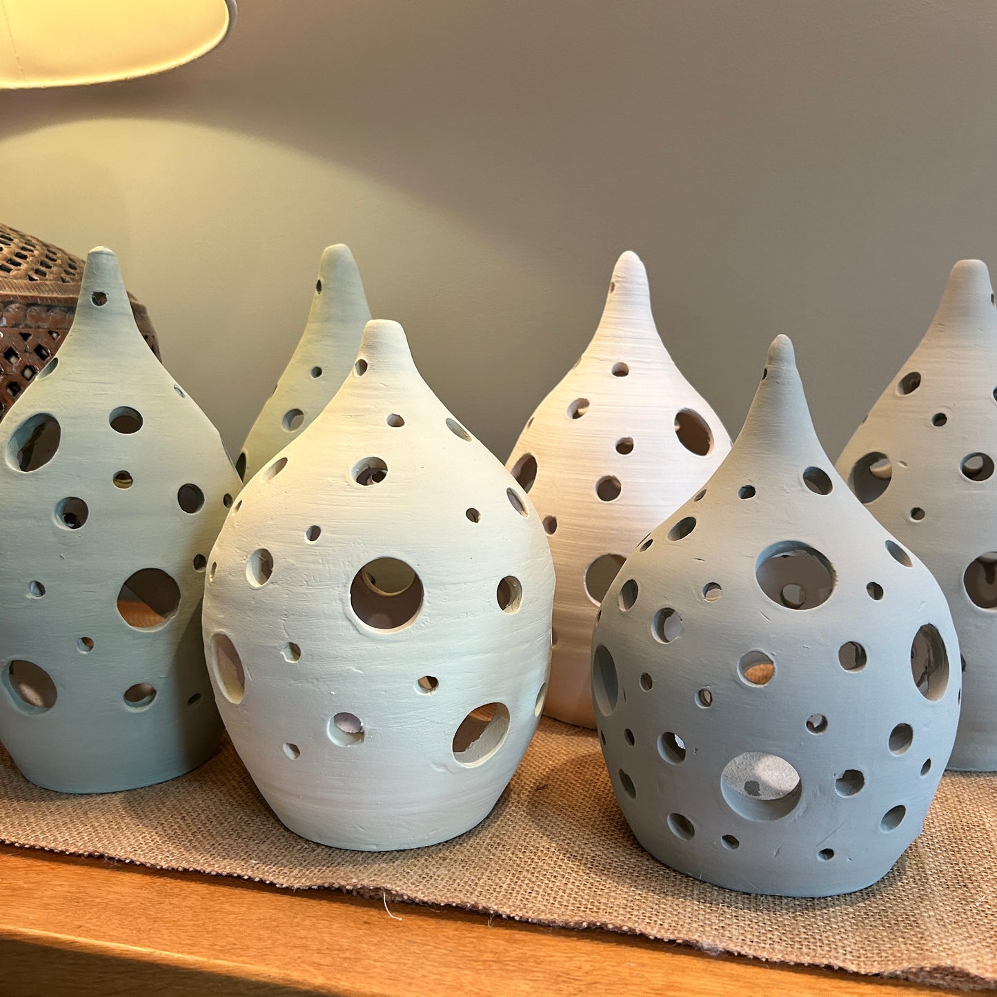 6 pottery lanterns with holes across them, 4 in green colour and 2 in white 