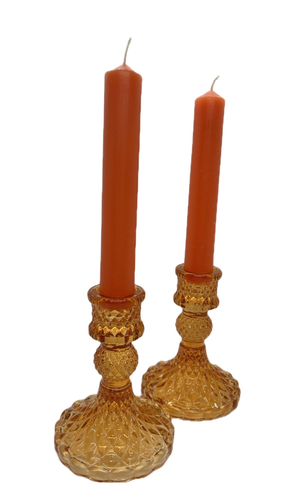 two orange glass candle sticks with orange dinner candles 