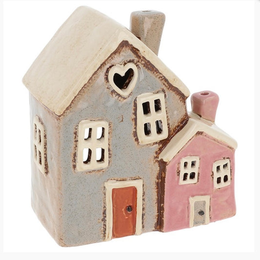 Grey pink ceramic house tealight holder with white roof and cutout windows 