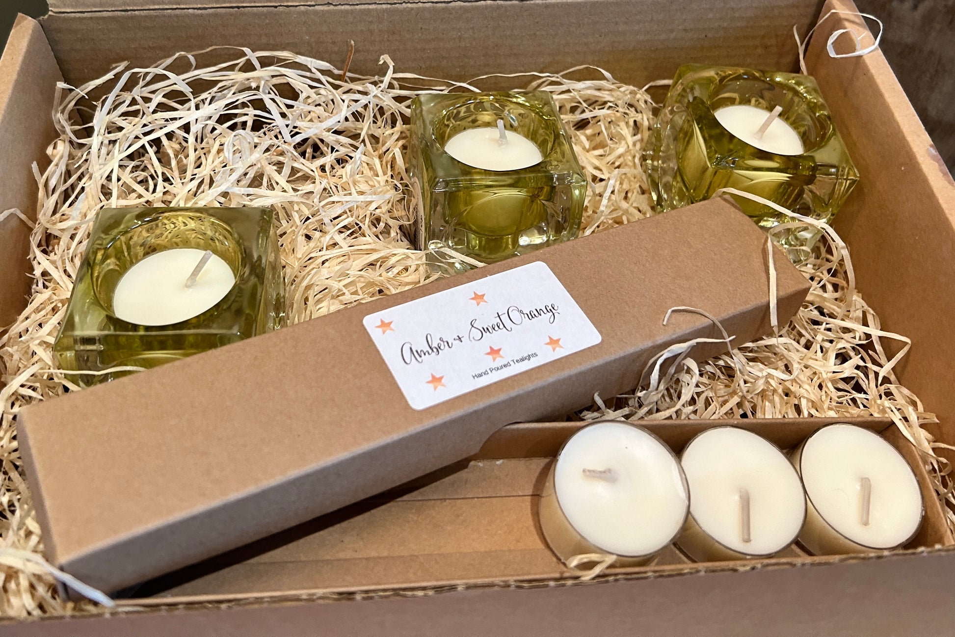 box of Green tealight holders, tea lights and wrapped in wooden shredded packaging 