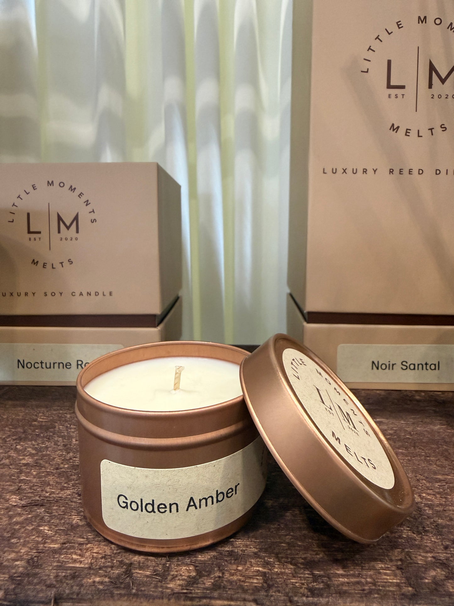 Copper colour tin candle on a wooden shelf 